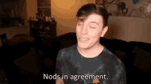 a man in a tie dye shirt says nods in agreement in a living room