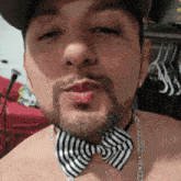 a man with a beard wearing a striped bow tie and chain around his neck