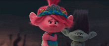 a couple of trolls standing next to each other with one wearing a crown