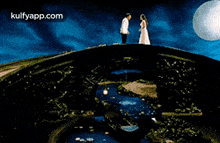 a man in a tuxedo and a woman in a white dress are dancing on a bridge .