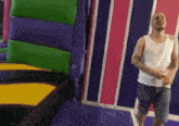 a man in a white tank top is dancing in a room