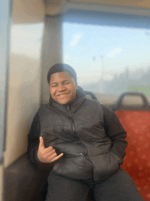 a young man wearing a black vest with the word nike on it is smiling and giving a thumbs up