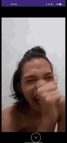 a man is laughing while covering his mouth with his hand .