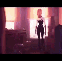 a woman is standing in front of a window in a room .