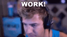 a man wearing headphones is sitting in front of a computer screen and saying `` work '' .