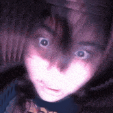 a close up of a person 's face with a purple background and a shirt that says ' a ' on it