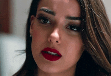 a close up of a woman 's face with red lips .