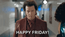 a man in a suit and tie is standing next to a woman in a hallway and saying `` happy friday '' .