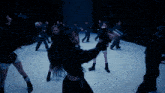 a large group of people are dancing on a blue surface
