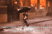 a man holding an umbrella in the rain says welcome to benchmark bank