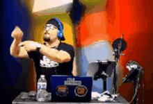 a man wearing headphones is standing in front of a laptop that says ' shawn ' on the screen