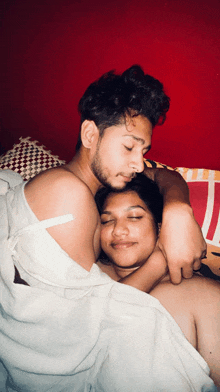 a man and a woman are laying on a bed