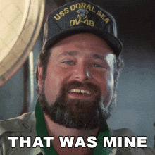 a man with a beard wears a hat that says uss coral sea on it