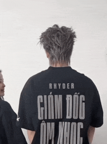 a man wearing a black shirt that says rhyder