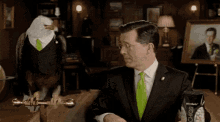 a man in a suit and tie is standing next to a bald eagle wearing a suit and tie .