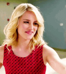 a close up of a woman wearing a red dress and smiling .