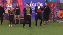 a group of people are dancing in front of a sign that says y legalon no