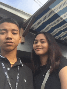 a man and a woman are posing for a picture and the man has a lanyard that says black