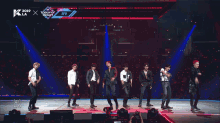 a group of young men are performing on a stage in front of a screen that says ' all boom ' on it