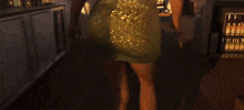 a woman in a green sequined dress stands on a balcony