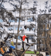 a man in a white shirt is standing on a metal pole