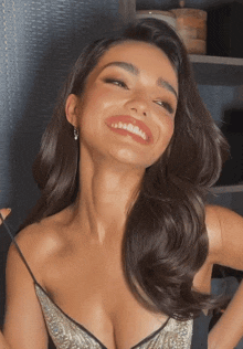 a woman wearing a plunging neckline and earrings smiles