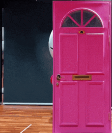 a pink door with a mailbox on the door