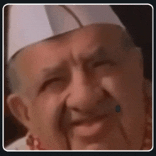 a close up of a man wearing a chef 's hat and making a funny face .