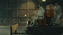 a group of people are sitting in a room with a sign that says ' a ' on it