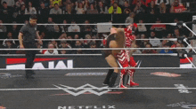 a wrestler is laying on the ground after being knocked out during a match .