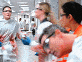 a group of people wearing safety goggles and gloves are walking down a hallway