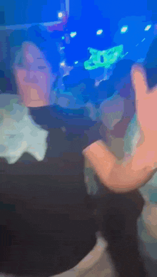 a blurry picture of a person in a dark room with a blue background