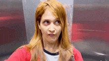 a woman in a red jacket making a funny face