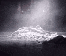 a pile of rocks is sitting on the ground in a dark room with smoke coming out of it .