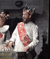 a man wearing a keep calm and carry on sash around his neck