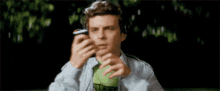 a person is taking a picture of a person wearing a scream mask on their cell phone .