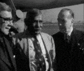 a black and white photo of three men in suits