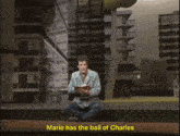a man sits on the floor reading a book with the words marie has the ball of charles below him