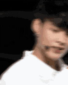a blurry picture of a man wearing a white shirt and a black hat .