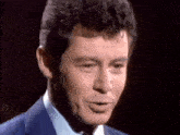 a close up of a man in a suit and tie making a face .
