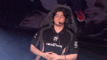a man wearing headphones and a shirt that says heretics on it