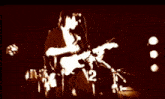 a man is playing a guitar with the number 12 on the bottom