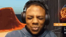 a man is wearing headphones and making a funny face while playing a video game .