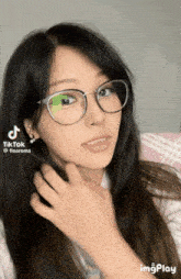 a woman wearing glasses is making a funny face