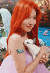 a woman with red hair is holding a small white rabbit with chinese writing on her arm