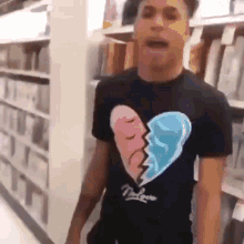 a man wearing a broken heart shirt is standing in a store .
