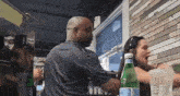 a man and woman are sitting at a table in front of a sign that says " taco bell "