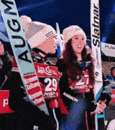 a woman holding a pair of skis that say ' slatnar ' on it
