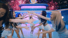 a group of women are dancing in front of fireworks