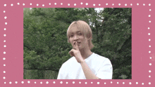 a man in a white shirt with his finger on his lips